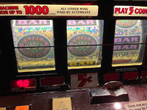 The face of the old coin operated slot machine shows TRIPLE DIAMOND - TRIPLE DIAMOND - DOUBLE BAR, WHICH PAYS 3 x 3 x 100 = 900 NICKEL COINS